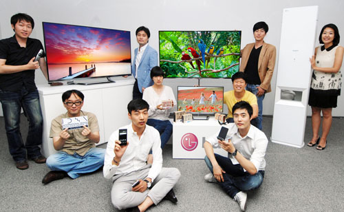 People hold an array of LG's latest products that have received accolades from the Industrial Designers Society of America (IDSA) and the International Design Excellence Awards (IDEA)