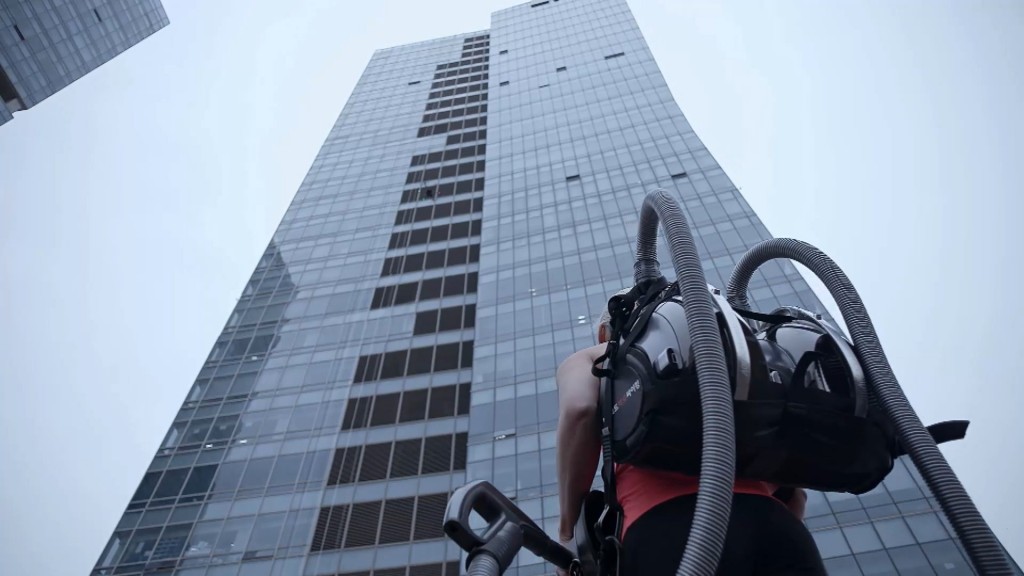 Professional rock climber Sierra Blair-Coyle with LG CordZero™ canister vacuum standing in front of 33-story office tower