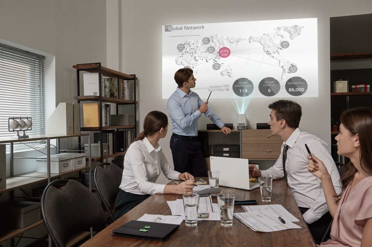 A work team use the LG Probeam Projector for their meeting in the office