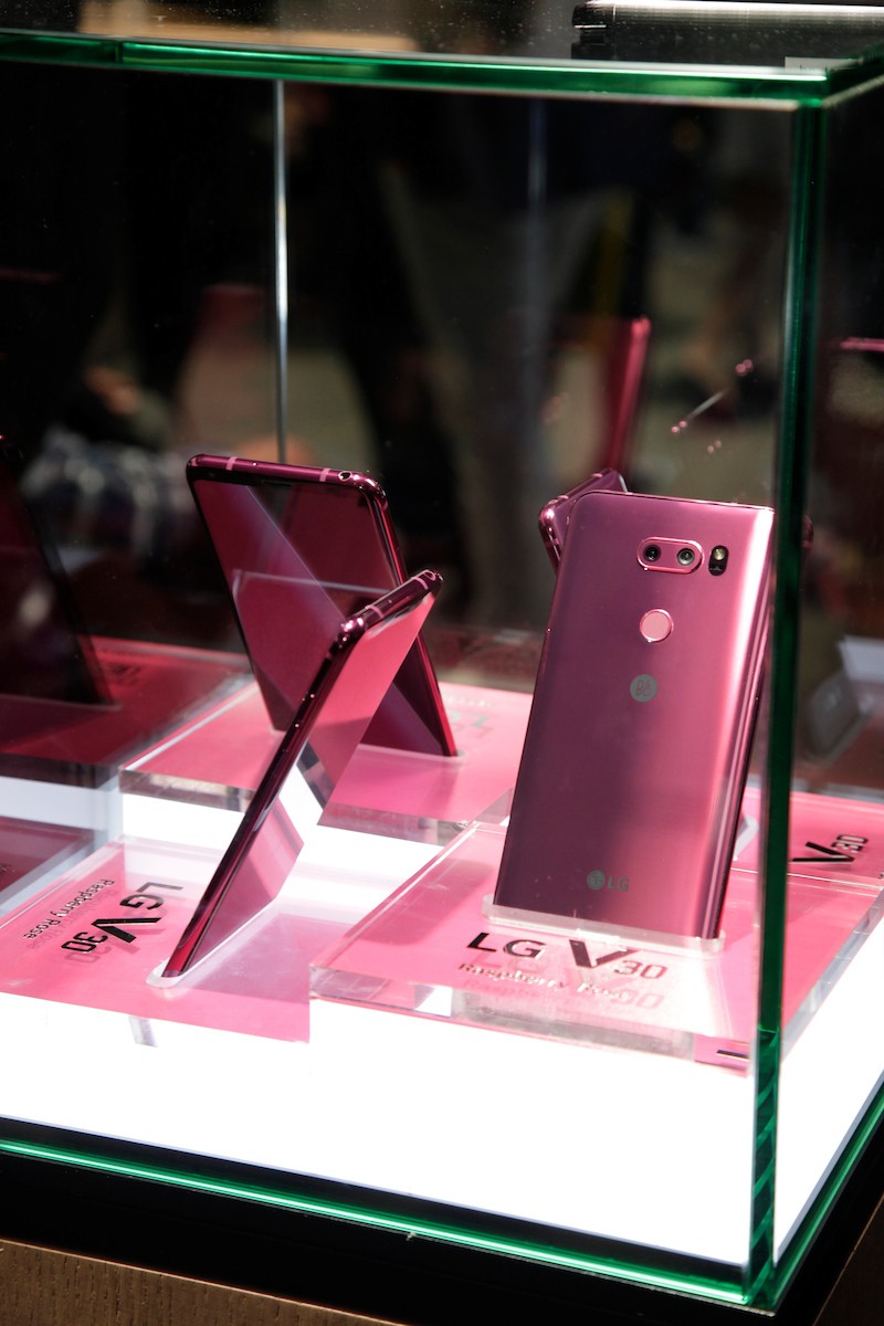 Several LG Raspberry Rose V30 smartphones showcased inside a glass display at LG’s CES 2018 booth.