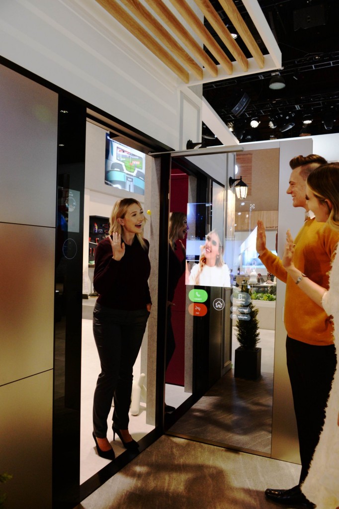 Another view of a woman waving to her friends after using LG ThinQ’s Smart Door concept which was showcased at CES 2020